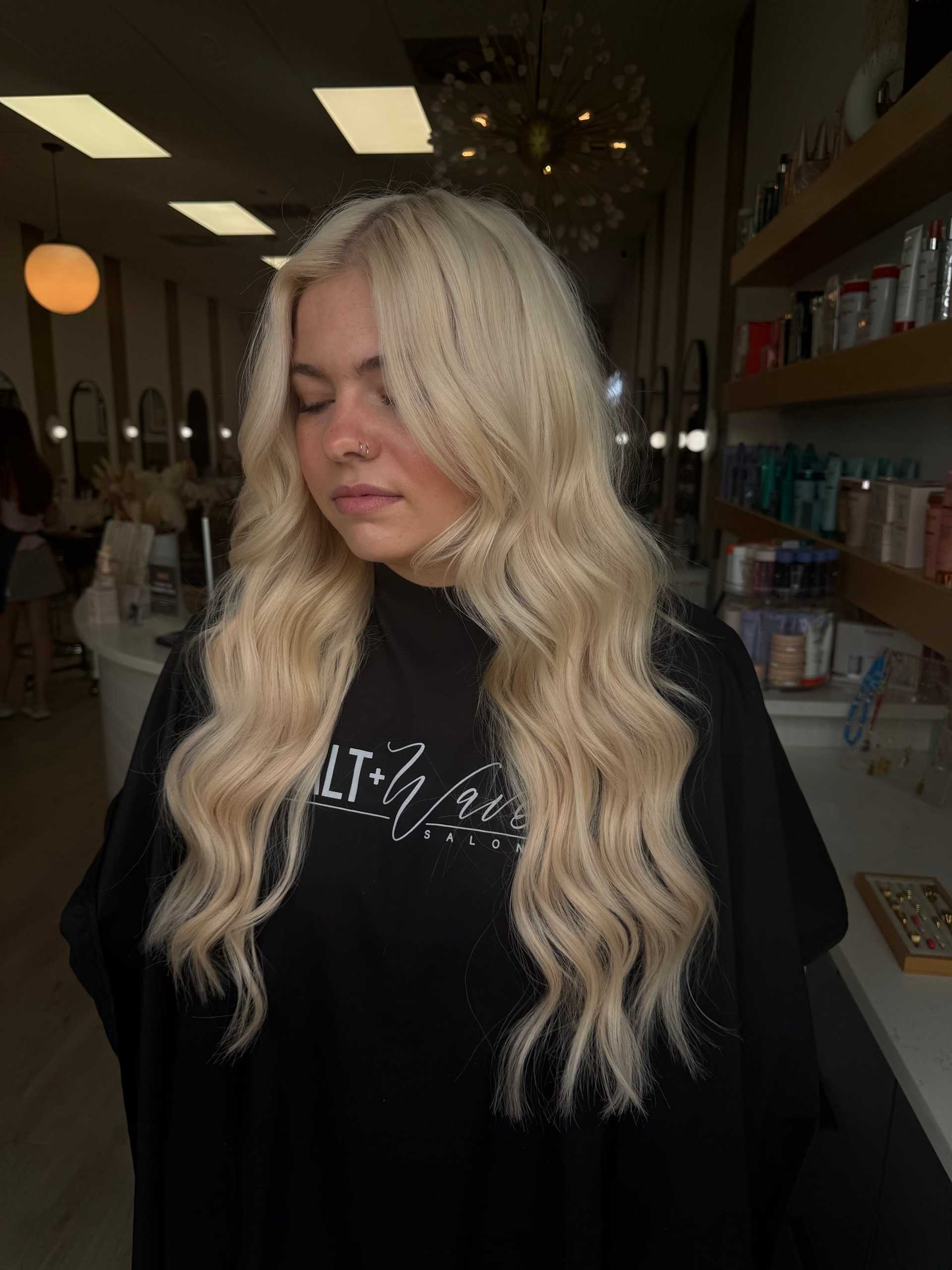 Woman with long, wavy blonde hair at a salon.
