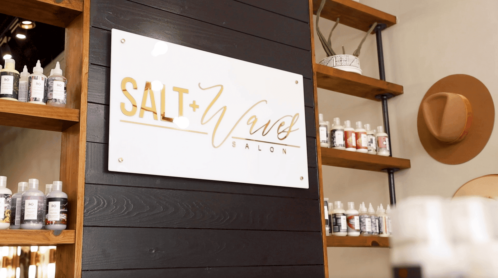 Salt + Waves Salon interior with product shelves and stylish decor.