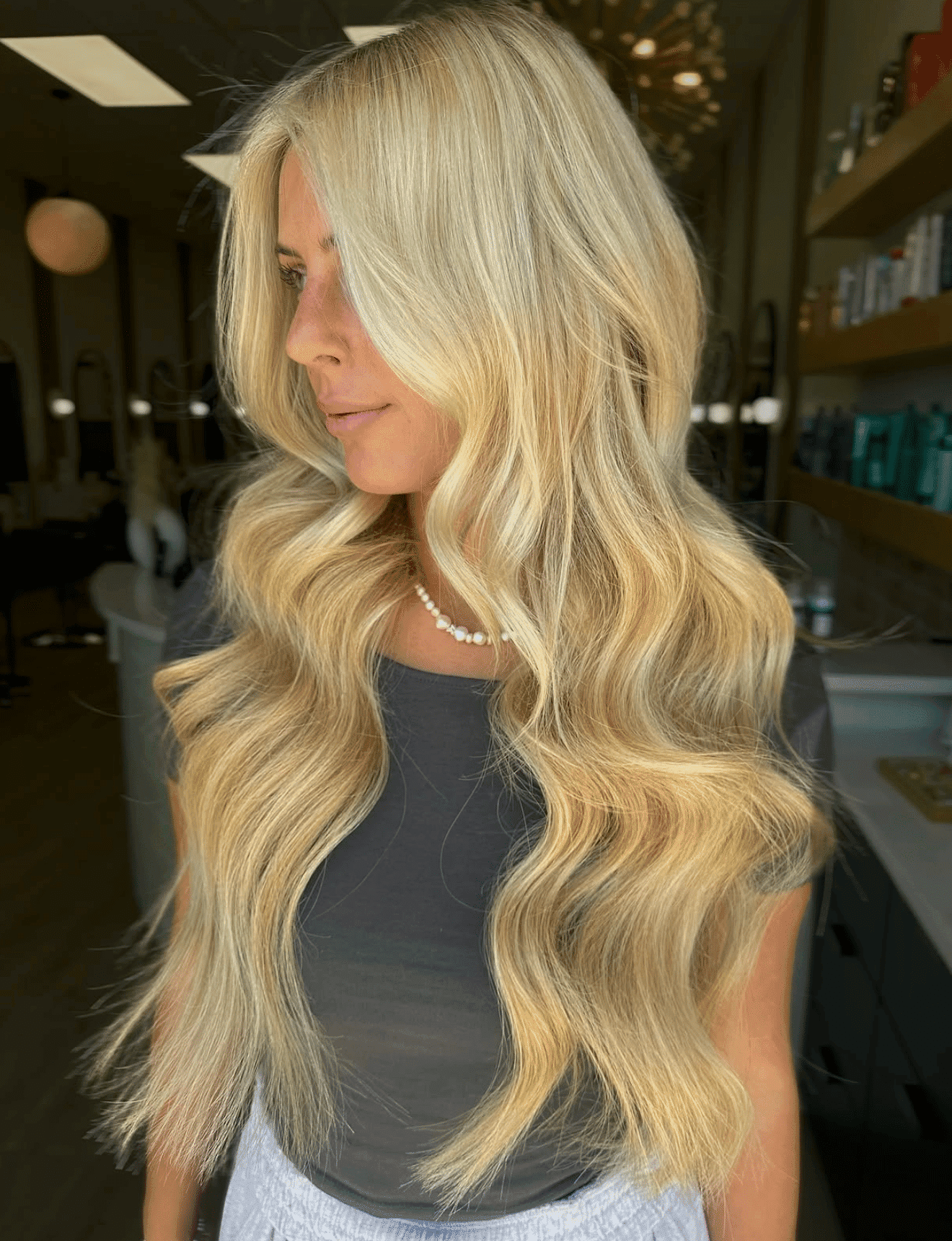 Blonde woman with long wavy hair in a salon.